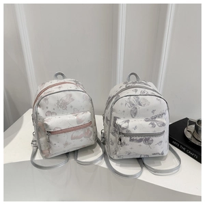 Detail of mini backpack texture with pink and grey butterfly patterns and silver zippers