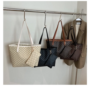 Détail de quatre sacs cabas avec monogrammes en beige, noir et marron et petites pochettes