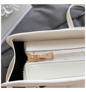 Close-up of white lychee grain leather Boston bag with premium gold metal zipper detail
