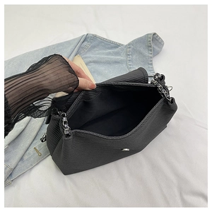 Detail of spacious black pleated shoulder bag interior with metal chain strap