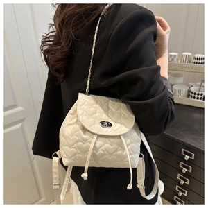 Detail of cream backpack featuring heart-shaped quilting and silver twist-lock closure