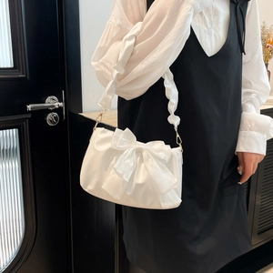 Glossy white underarm bag with large bow and ruffled strap for stylish summer fashion