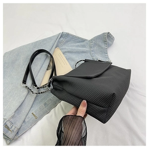 Detailed texture view of black woven crossbody bag with elegant metal chain strap