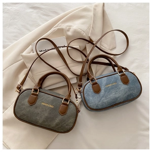 Macro detail of retro denim mini Boston bags with leather handles and gold metal hardware