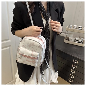 Detailed macro of white mini backpack with pink butterfly prints and silver metal zippers