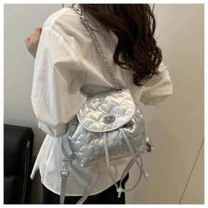 Silver heart quilted backpack showing size and scale on a model with chain straps