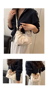 Detail of canvas bucket bag featuring amber beaded handle and cute bear graphic print