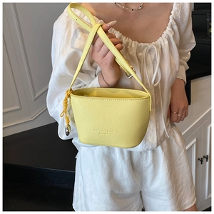 Detail of yellow crossbody bag with lychee texture leather and fashion logo