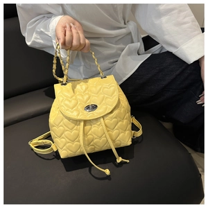 Detail of yellow mini backpack with heart quilting and golden chain strap handle