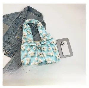 Detailed top view of light blue floral handbag featuring a decorative white ribbon bow