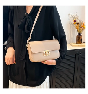 Detail view of apricot crossbody bag with elegant golden geometric clasp and matte finish