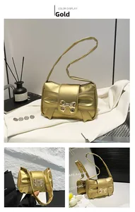 Detailed view of the gold crossbody bag with a 3D folded bow and metallic finish