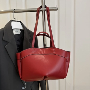 Red leather tote bag with white contrast stitching and dual handles for shoulder carry