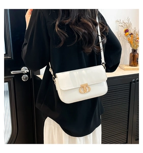 Detailed view of a white PU crossbody bag featuring a luxury gold rotating metal buckle