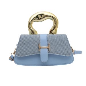 Light blue crossbody bag with metallic top handle and elegant H-shaped golden buckle