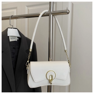 Détail de la texture cuir litchi blanc avec boucle dorée sur un sac à bandoulière chic