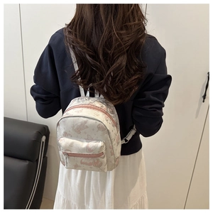 Rear view of a mini backpack with pink butterfly prints and a front zipper pocket