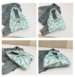 Close-up of light blue floral handbag with large bow detail and 3D flower appliques