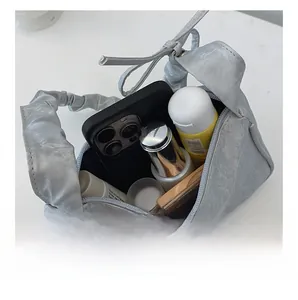 Interior view of pleated metallic bag showing space for phone and cosmetics