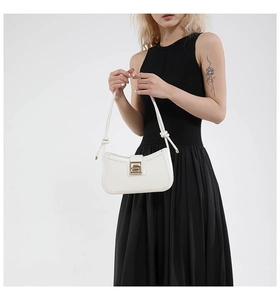 Detail of white hobo bag with a gold rectangular buckle and knotted leather shoulder strap