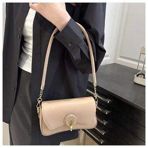 Detalle del bolso de hombro beige claro con acabado en cuero liso y hebilla dorada redonda