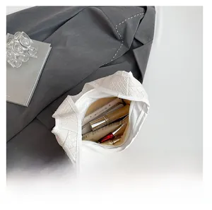 Interior view of white woven leather bucket bag showing large capacity for cosmetics