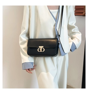 Detailed close-up of a black PU leather crossbody bag with a golden metal twist lock