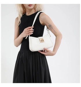 Close-up of sleek white underarm bag featuring a minimalist gold geometric buckle