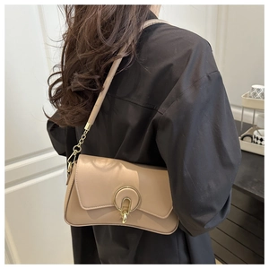 Detail of beige shoulder bag with golden metal buckle and chain on white background