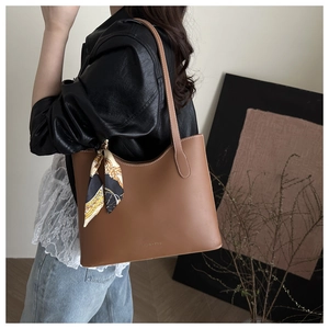 Detail of soft brown leather tote bag with vintage scarf decoration and stitching