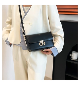 Close-up of elegant black PU leather crossbody bag with polished gold D-ring buckle detail