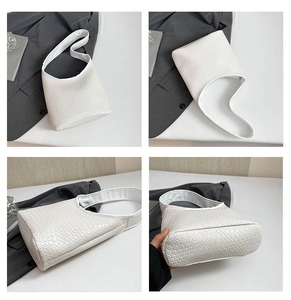 Close-up showing the intricate woven texture and smooth zipper detail of the white tote bag