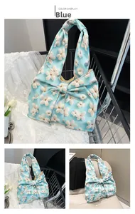 Detail of floral printed blue tote bag featuring a large bow knot and textured fabric