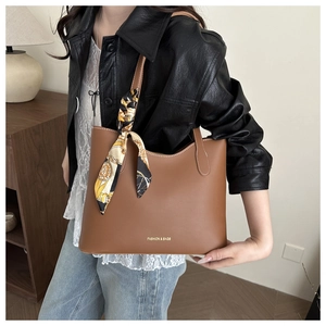 Brown leather tote bag featuring a silk scarf on the handle and Fashion & Bags gold text