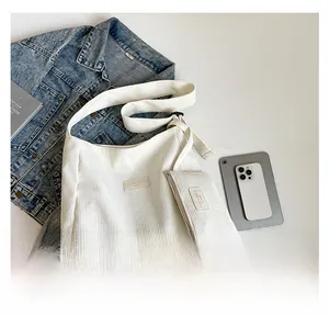 Detail view of white corduroy tote bag with mini zipper pouch and textured vertical stripes