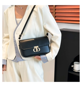 Detail view of a black PU leather crossbody bag with a gold metal twist-lock buckle closure