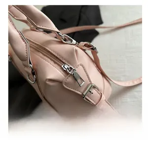 Détail de la fermeture éclair argentée et de la boucle réglable du sac à main rose