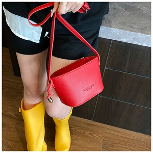 Detail view of red lychee pattern bucket bag with adjustable strap and metal ring