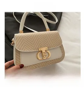 Gros plan du sac à main en paille tressée et cuir blanc avec boucle en métal doré chic