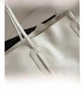 Close-up of leather texture and stitching detail on the white tote shoulder bag