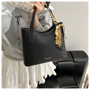 Détail d'un grand sac cabas noir avec surpiqûres blanches et foulard en soie floral