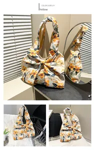 Detail of floral shoulder bag featuring a large 3D bow design and vibrant yellow flower print