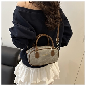 Detail of vintage canvas bowling bag with leather straps worn by a model on shoulder