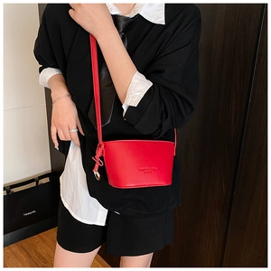 Detail of red lychee pattern bucket bag featuring embossed text and side knot detail