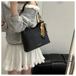 Détail du sac cabas noir avec coutures contrastées blanches et poignée en foulard de soie