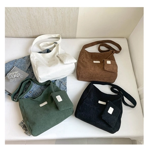 Flat lay of corduroy tote bags in four colors with matching mini zipper pouches