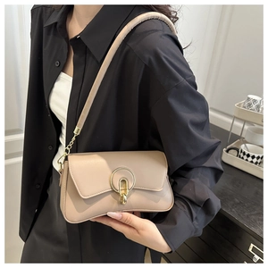 Detail of beige crossbody bag with gold metal buckles on a shoulder strap for women