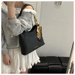 Détail du sac cabas en cuir noir avec surpiqûres blanches et foulard en soie décoratif