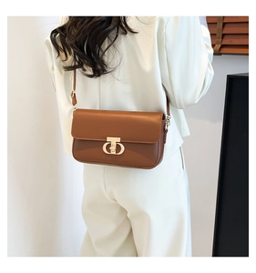 Brown PU leather shoulder bag featuring a golden metallic twist lock and elegant thin strap