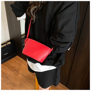Detail of red lychee textured bucket bag with fashion embossing and knot strap details